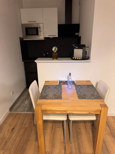 Il dispose d'une cuisine et d'une table à manger avec des chaises blanches. dans l'établissement Marechaux, à Mulhouse