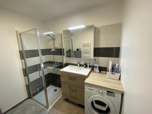 une salle de bain avec un lavabo et une machine à laver dans l'établissement Superbe appartement 3 pièces avec vue mer, à Saint-Cyr-sur-Mer