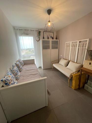 une chambre avec un lit, un canapé et une fenêtre dans l'établissement Superbe appartement 3 pièces avec vue mer, à Saint-Cyr-sur-Mer