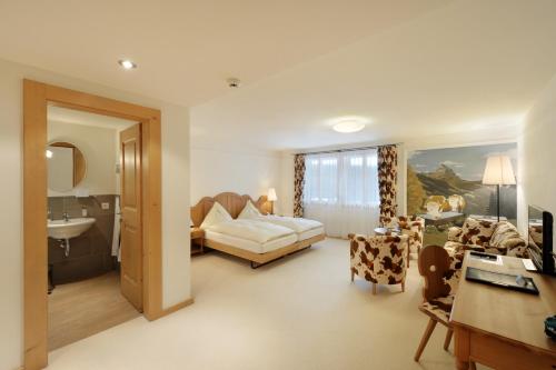 uma ampla sala de estar com um sofá e um lavatório em Hotel Bellerive Gstaad em Gstaad