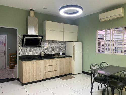 a kitchen with a refrigerator and a table with chairs at Sama House in Phnom Penh