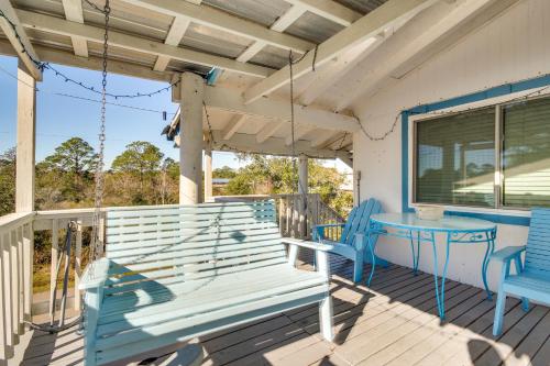 a porch with a blue bench and a table at 5 Mi to Beach Bay St Louis Home with Launch and Dock in Shoreline Park