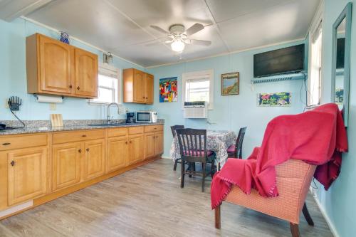 a kitchen with wooden cabinets and a table and chairs at Studio about 5 Mi to Waveland Beach and Pier! in Shoreline Park