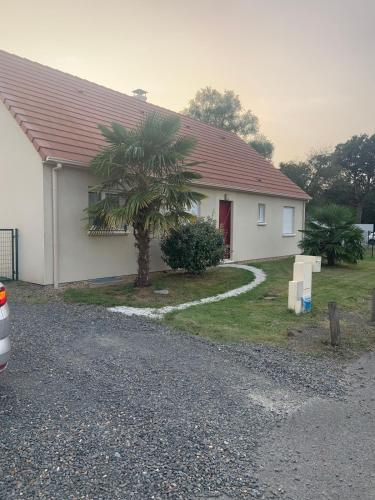 une maison avec un palmier devant dans l'établissement Loue Maison événement circuit 24 heures Le Mans, à La Suze-sur-Sarthe
