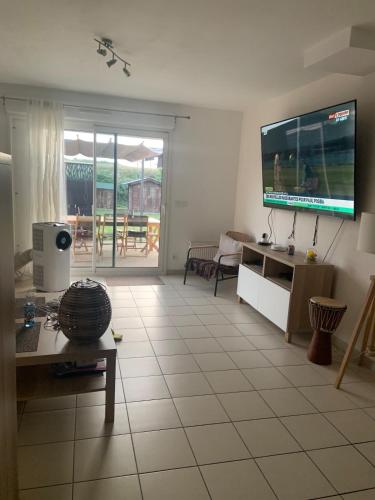 un salon avec une grande télévision à écran plat dans l'établissement Loue Maison événement circuit 24 heures Le Mans, à La Suze-sur-Sarthe