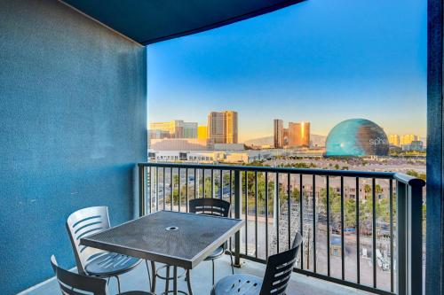 a table and chairs on a balcony with a view of the city at SPHERE IN 4K - Vintage Vegas Condo with Sphere and Strip Views! in Las Vegas