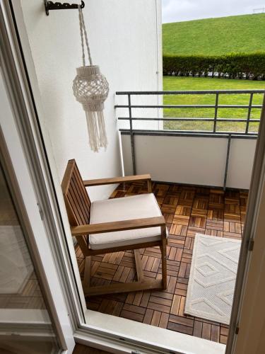 a chair on a balcony with a chandelier at Meerliebe in Cuxhaven
