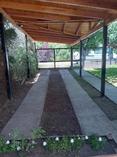 a covered walkway in a park with a wooden roof at Cabaña con costa al Lago Nahuel Huapi in San Carlos de Bariloche