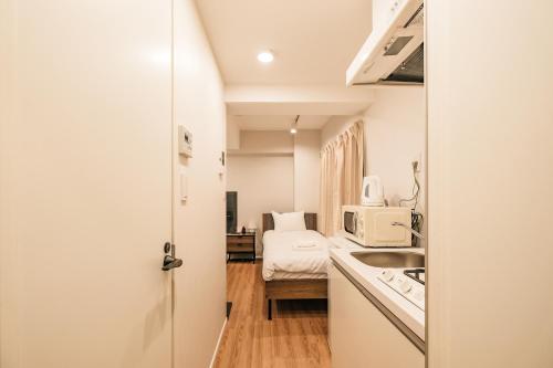 a small room with a kitchen and a bed at Mi-HOTEL ASAKUSA in Tokyo