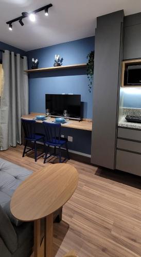 a living room with a table and chairs and a kitchen at STUDIO104 - Novo e completo na melhor localização de Pinheiros, próximo ao Metrô Fradique Coutinho in Sao Paulo