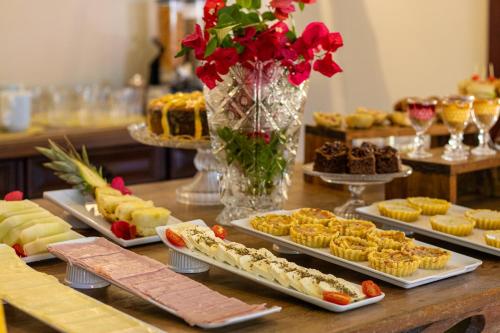 a table topped with trays of desserts and cakes at EstrelaMar Ferradura Restaurante & Spa in Búzios