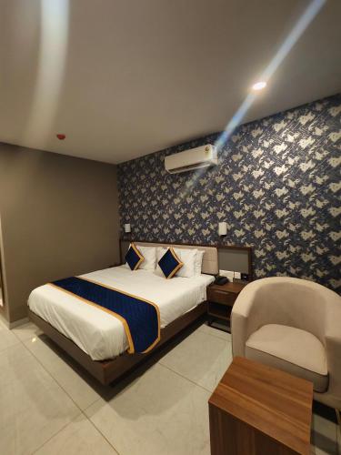 a hotel room with a bed and a chair at Blue Diamond Residency in Perintalmanna