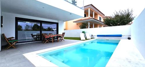 a swimming pool in the backyard of a house at Maison bord mer près de le Lisbonne in Charneca