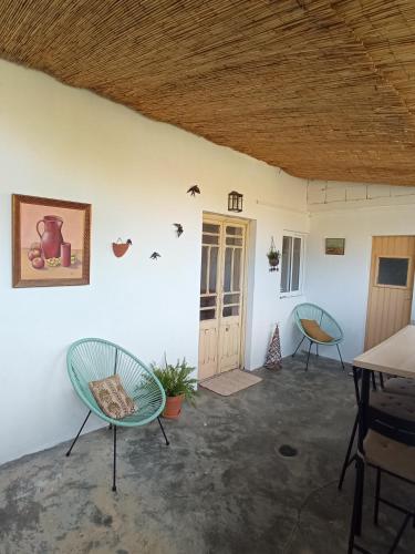 a room with two chairs and a table and a door at Montijo Garden - Studio with garden view in Montijo