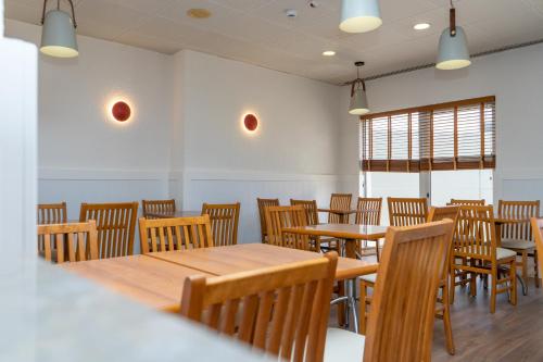 a dining room with wooden tables and chairs at Flag Hotel Lisboa Oeiras in Oeiras