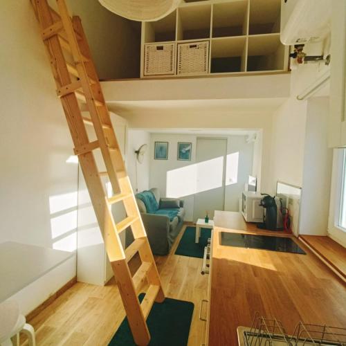 - une mezzanine dans un salon avec une échelle dans l'établissement Nest- Tiny house avec Jardin, proche gare, Luxembourg-Metz, à Uckange