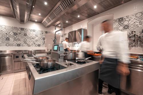 three people in a kitchen with pots and pans at Villa Magia in Positano