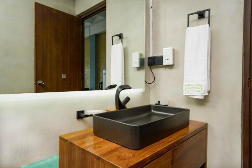 a bathroom with a black sink and a mirror at Kelvin Eco Resort in Dedugala