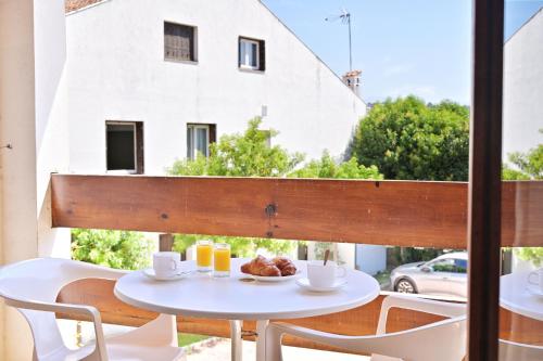 une table avec une assiette de nourriture sur un balcon dans l'établissement Motel de Porticcio, à Porticcio