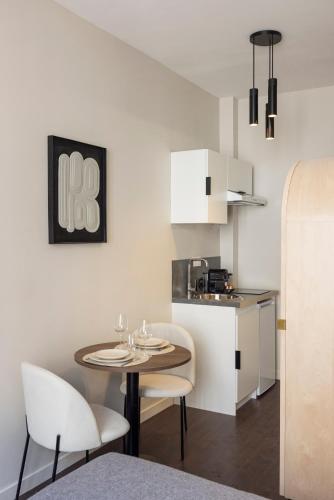 une cuisine avec une table et deux chaises et une cuisine avec un comptoir dans l'établissement Serenity spot 5 minutes away from Paris-II, à Le Pré-Saint-Gervais