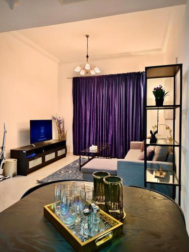 a living room with a table with glasses on it at Cozy 1Bhk With Corniche View in Sharjah