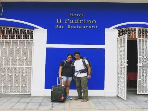 a man and woman standing in front of a blue building at Hotel il Padrino in Granada