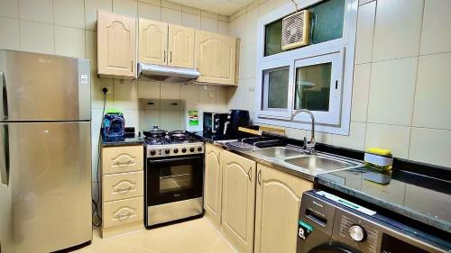 a kitchen with a stainless steel refrigerator and a sink at Cozy 1Bhk With Corniche View in Sharjah