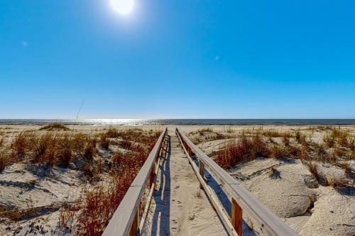 a boardwalk to the beach with the ocean in the background at As Pelicans Pass in Indian Pass