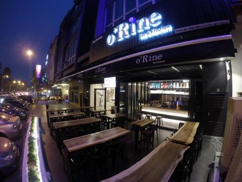 a bar with tables and chairs in front of a building at Here Hotel in Skudai