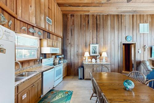a kitchen with wooden walls and a wooden table at As Pelicans Pass in Indian Pass