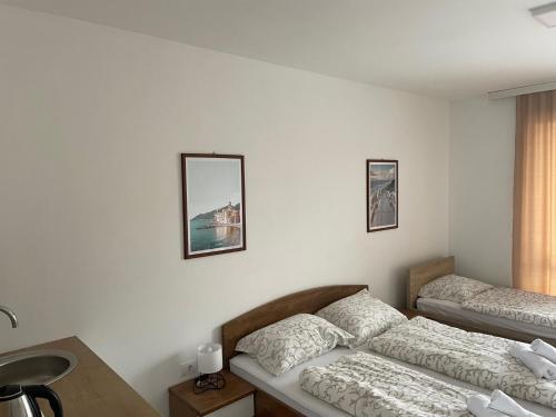 una camera con due letti, un tavolo e uno specchio di Novel S&S a Veliko Gradište
