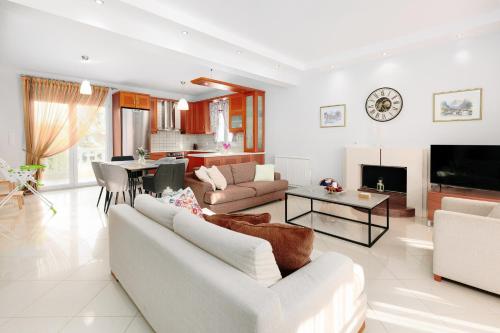 Una sala de estar con dos sofás y un televisor. en Meli-Anas House, en Nea Iraklitsa