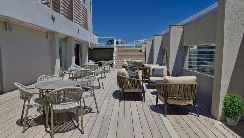 a wooden deck with tables and chairs on a balcony at Amérian Córdoba Park Hotel in Córdoba