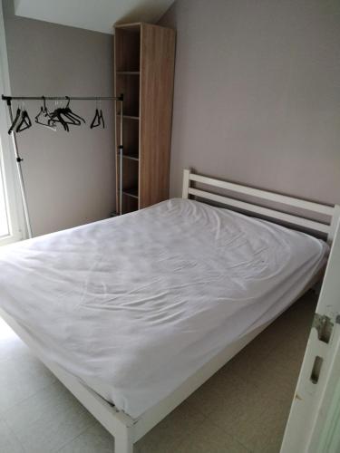 - un lit blanc dans une chambre avec placard dans l'établissement clos st paul, à Fort-Mahon-Plage