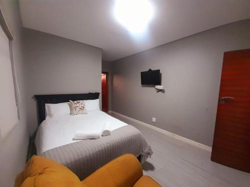 a bedroom with a bed and a tv on the wall at Dali in Kiddʼs Beach