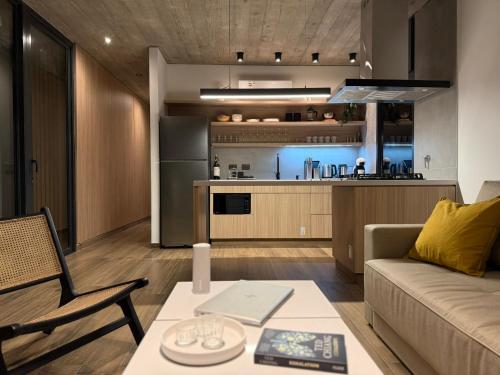 ein Wohnzimmer mit Couch und Tisch und eine Küche in der Unterkunft Terrazas del Bosque in La Pedrera