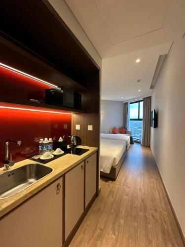 a kitchen with a sink and a bed in a room at Apec Mandala Romantic Mui Ne in Ấp Thiẹn Ái