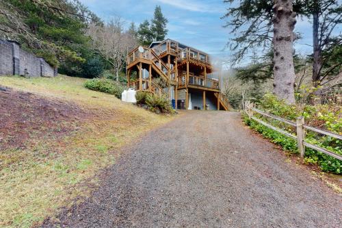 una casa en una colina con una carretera delante de ella en Playing Coast, en Tillamook