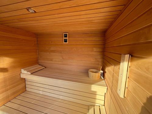a small wooden sauna with a bucket in it at Villa Estelle - pool, jacuzzi, sauna - Balaton in Balatonkenese