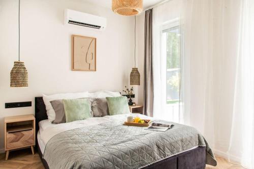 a bedroom with a bed with a tray of fruit on it at Villa Estelle - pool, jacuzzi, sauna - Balaton in Balatonkenese