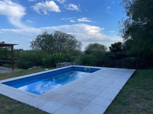 ein kleiner Pool im Gras mit einem Himmel in der Unterkunft Casa con pileta - Rio Ceballos - a 5 min del centro - Hermosa vista a las sierras in Río Ceballos