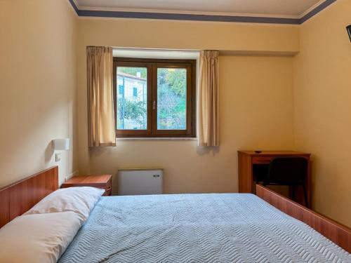 a bedroom with a large bed and a window at Fanesia coliving in Fano Adriano