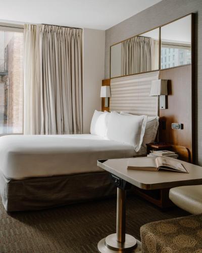 a hotel room with a large bed and a table at Hotel Boutique at Grand Central in New York