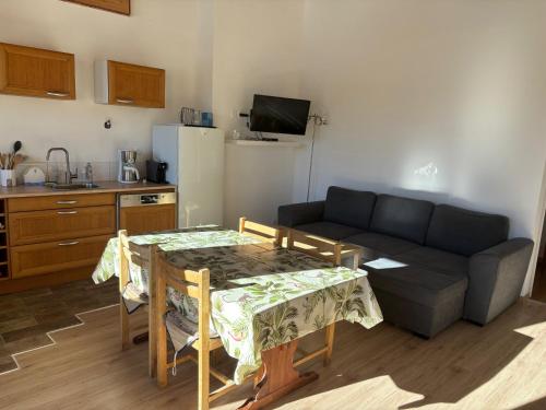 a kitchen and a living room with a table and a couch at Les Balcons de L'Izoard in Arvieux