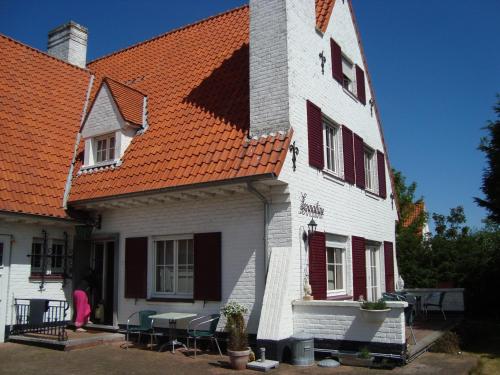a large white building with an orange roof at B&B Villa Fernadine in De Haan