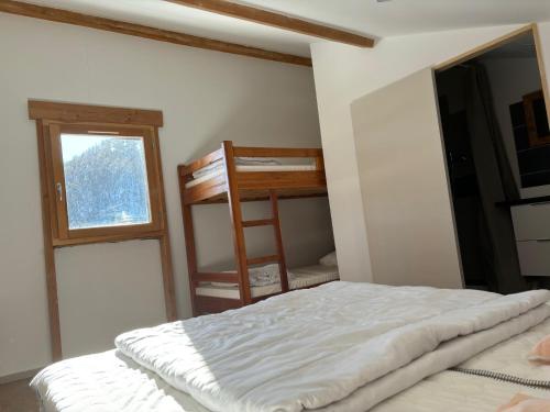 a bedroom with a bed and a window and a ladder at Les Balcons de L'Izoard in Arvieux