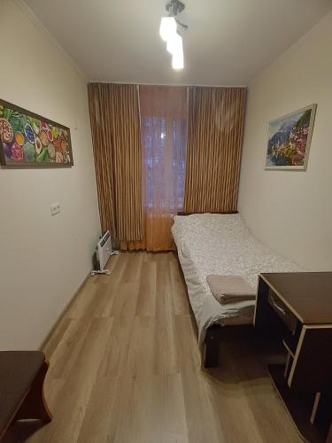a bedroom with a bed and a desk and a window at Cozy rooms near beautiful Park 1st Floor in Chişinău