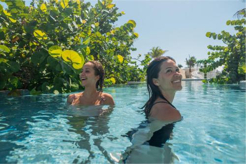 two women in the water at a resort at Palmaïa The House of AïA All Inclusive Wellness Resort in Playa del Carmen