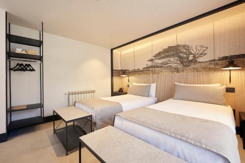a hotel room with two beds and a table at Hotel Las Torres Patagonia in Torres del Paine