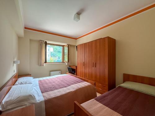 a small bedroom with two beds and a window at Fanesia coliving in Fano Adriano